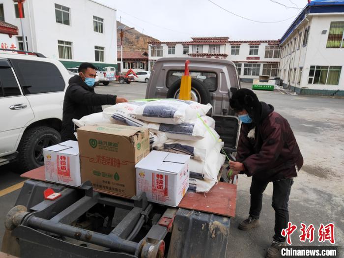 甘孜縣工作人員為村民領(lǐng)取分派的物資。　劉炳科 攝