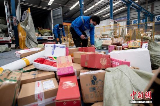 資料圖：2月20日，山西省太原市，在中通快遞山西轉運中心，員工戴著口罩分揀包裹。中新社記者 韋亮 攝